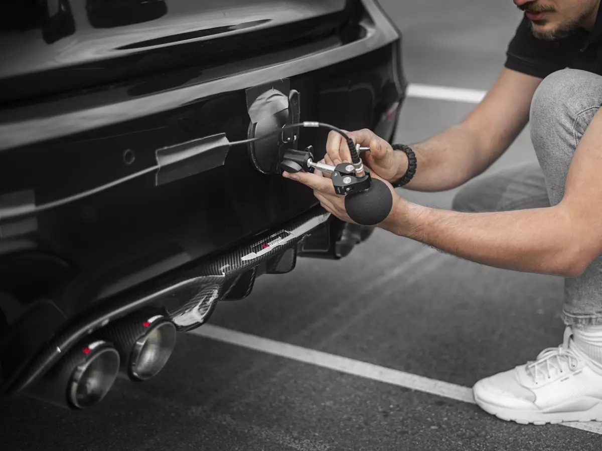 A man testing a car with a microphone.